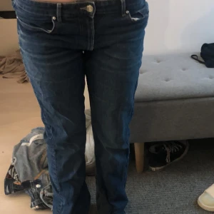 Bootcut jeans high waist &Denim - Säljer ett par mörkblå bootcut jeans från &Denim i storlek 44. Modellen har hög midja och klassisk femficksdesign. Jeansen är tillverkade i denim och har en snygg bootcut passform som ger en schysst siluett. Perfekta för dig som gillar retrovibbar och bekväma jeans.