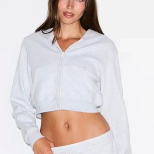 Ljusgrå croppad hoodie med dragkedja - Snygg cropped hoodie. Knappt använd har inte haft någonstans att ha på mig. Skriv för mer info