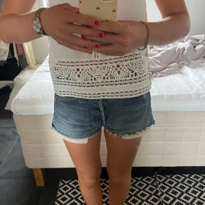 Levi's blå jeansshorts med fransar - Säljer ett par klassiska blå jeansshorts från Levi's med råa fransade kanter och fem fickor. Shortsen har låg midja och en normal passform, perfekt för chill dagar. Ikonisk Levi's-detalj med röd etikett på bakfickan. Supernice till sommarens alla häng! Storlek 28