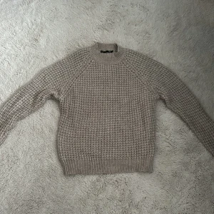 Beige stickad tröja från 157 - Säljer en beige stickad tröja från 157 i storlek S. Tröjan har grovstickat mönster, rund hals och långa ärmar. Perfekt för dig som gillar chill och enkel stil. Passar dig som vill ha en mysig och snygg tröja till hösten eller vintern.