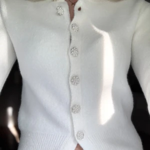 Vit kofta med pärlknappar från Zara - Varsamt använd‼️Superfin vit kofta med lång ärm och snygga pärlknappar i blomform längs hela framsidan. SUPER mjuk och fluffig, passar perfekt nu till sensommar/höst och vinter!