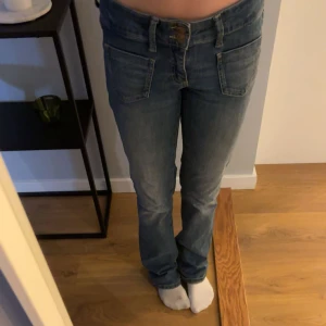 Blå jeans från Vero Moda - Snygga blå jeans från Vero Moda med klassisk fyrficksdesign och dubbla knappar i midjan. Jeansen har en rak passform och är tillverkade i mjukt denim-material. 