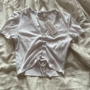 Vit croppad topp med snörning - Supersnygg vit croppad topp från FBsister. Prislapp kvar på toppen.