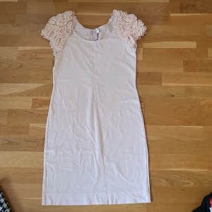 Kortklänning med volangärmar H&M - Supersöt ljusrosa kortklänning från H&M Garden Collection med unika volangärmar i blommig stil. 