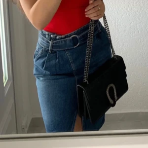 Jeanskjol från Ginatricot  - Helt ny kjol från Ginatricot, har en öppning framtill och kan spännas med tillhörande skärp.