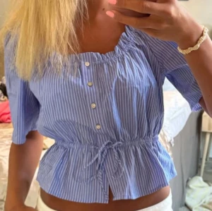 Blåvit randig blus med knyt - Söt blus i blått med vita ränder, kort ärm och knappar framtill🥰
