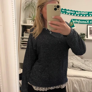 Mörkblå stickad tröja med spetskant - Mysig mörkblå stickad tröja med lång ärm och rund hals. Nedtill syns en söt vit spetskant som ger en extra detalj. Perfekt för lager-på-lager och chill dagar. Passformen är normal och materialet känns mjukt och skönt mot huden.❣️