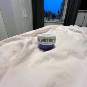 Sol de Janeiro Delicia Drench Body Butter💜Aldrig använd!! - Sol de Janeiro Delicia Drench Body Butter med Cheirosa 59-doft. Kommer i en rund burk med vit lock och lila botten. Innehåller prebiotisk hibiskus och Brazilian Soothing Complex för extra återfuktning och mjuk hud. HELT OANVÄND!!!💜💜