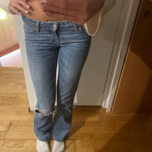 Blå jeans från Levi's - Säljer ett par klassiska blå Levi's jeans i bra skick. De är lågmidjade med en straight/bootcut passform och har en snygg slitning vid knäet. Perfekta för både vardag och fest! 🕺 storlek xs Måtten är: midjemått, 36. Innerbenslängd 84 cm