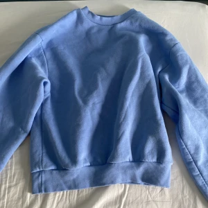 Ljusblå sweatshirt från Gina Tricot XS - Enkel och snygg ljusblå sweatshirt från Gina Tricot, basically basics-kollektionen. Lite större i storleken och har nästan aldrig används då den inte riktigt är min stil. Den är väldig mjuk och skön inuti!🩵🩵 original pris är runt 300kr men säljs för 200kr då den aldrig används!