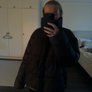 Svart pufferjacka med hög krage - Svart dunjacka från HM, väl använd i okej skicka. Lite sliten på ena ärmen, de sista bilden🖤
