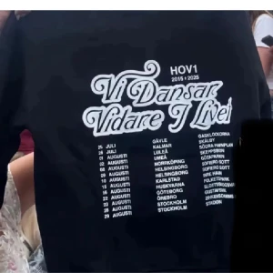 Svart Hov1 tourtröja med tryck - Säljer svart hov 1 hodie med tryck på ryggen: 'Vi Dansar Vidare I Livet' storlek xl men skulle säga      L/M då den är väldigt liten i storlek fortfarande i plast förpackning den som ger best får köpa