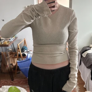 Tröja/topp - Tröja med långa ärmar från A-DSGN, några lösa maskor på framsidan men syns knappt på. Beige/grå
