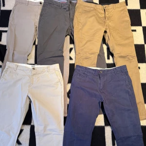 Flera chinos i olika färger - Fem par chinos i olika färger: beige, grå, sand, blå och khaki. Skriv om storlek och pris per styck eller bundle 
