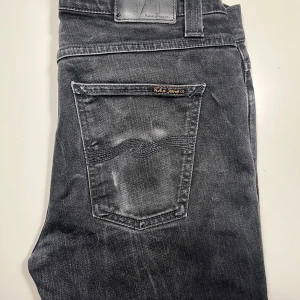 Svarta Nudie Jeans, storlek 32/32 - Säljer ett par svarta jeans från Nudie Jeans i storlek 32/32. Modellen är slim och har raka ben, perfekt för dig som bara vill ha en chill outfit🙌🏼pris kan diskuteras vid snabb affär och tveka inte att skriva vid funderingar👌🏼
