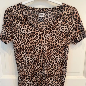 Leopardmönstrad t-shirt från PINK - Snygg t-shirt med skönt material från PINK by Victoria's Secret i leopardmönster❤️ Modellen har korta ärmar och v-ringad hals och är knappt använd!!🥰