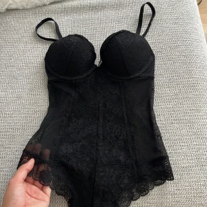 Svart spets body - Säljer en svart body med tunna axelband och vadderade kupor. Säljer denna på grund av att jag råkat köpa fel storlek, super snygg att ha som en fest topp. Skriv till mig och buda!!😙🩷