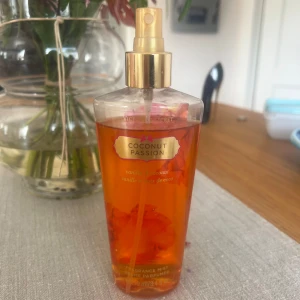 Victoria's Secret Coconut Passion mist - Fräsch body mist från Victoria's Secret i doften Coconut Passion med toner av vanilj och kokos. Flaskan är genomskinlig med guldigt spraymunstycke och rymmer 250 ml. Perfekt för dig som älskar söta, tropiska dofter och vill ha en lätt parfym till vardagen. Den är lite använd som ni ser på bilden