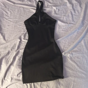 Svart halterneck klänning H&M Divided - Supersnygg svart kortklänning från H&M Divided i storlek XXS. Klänningen har halterneck och en tight passform som framhäver din figur. OBS liten i storleken!