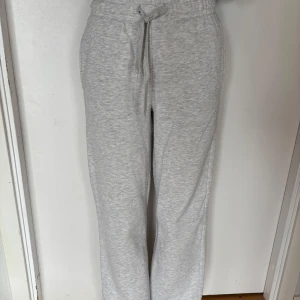 Grå mjukisbyxor från Gina Tricot XXS - Supermysiga grå mjukisbyxor från Gina Tricot, basically basics-kollektionen. De har en loose passform, hög midja och snörning i midjan. Materialet är mjukt och skönt, perfekt för chill dagar. Snyggt melerat tyg och klassisk look med raka ben.