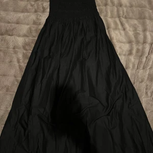 Svart långklänning med korsett  - Svart långklänning med axelband. Korsett 