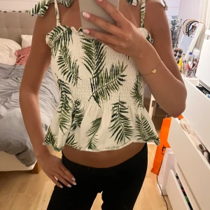 Vit topp med grönt mönster - Jättefin topp i storlek S som är köpt från H&M för längesen! 
