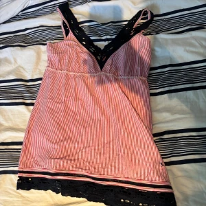 Randigt linne - Supersöt randig linnetopp från Bondelid i rött och vitt med svarta virkade spetsdetaljer vid axelband och nederkant.😊