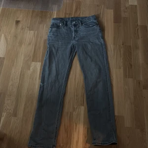 Levi's 501 grå jeans straight fit - Säljer ett par klassiska Levi's 501 jeans i grå tvätt. Jeansen har rak passform, fem fickor och den ikoniska läderpatchen bak i midjan. Materialet är slitstarkt denim och färgen är snyggt urtvättad för en cool look.