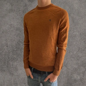 Rostbrun 100% merinoulls tröja Morris M - Snygg rostbrun stickad tröja från Morris i 100% merinoull. Klassisk rund halsringning och diskret broderad logga på bröstet. Perfekt för dig som gillar stilrena och bekväma plagg med en modern touch.