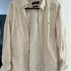 Morris Linné skjorta beige - En beige Morris skjorta i storlek S och har bara använt den fåtal gånger då den är lite stor för mig så den är så gott som ny, priset kan diskuteras vid snabb affär