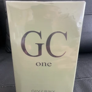 GC One parfym från Giverny - GC One från Giverny är en parfym i en stilren, ljusbeige kartong med stora svarta bokstäver. Förpackningen är rektangulär och tillverkad av kartong. Märket Giverny syns tydligt på baksidan tillsammans med ingredienslista och instruktioner. Luktar jättegott