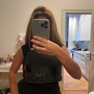 Svart ridväst - Ridväst som knappt är använd. Nypris 650kr. Kvitto finns. Den är längre där bak men fick ingen bra bild men den är perfekt för er som gillar att hoppa och utmana er själva lite inom ridsporten, till någon som vågar ta risker eller någon som bara vill känna sig säker. Storlek M. Pris kan diskuteras