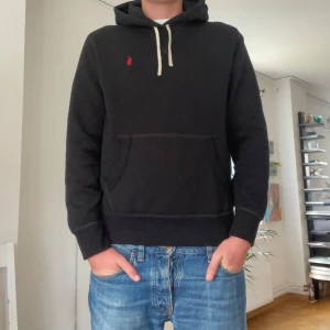 Svart hoodie från Polo Ralph Lauren - Svart hoodie från Polo Ralph Lauren med klassisk röd logga broderad på bröstet. Storlek M.