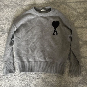Grå stickad tröja från Ami Paris - Säljer denna Snygga gråa stickad tröja från Ami Paris.