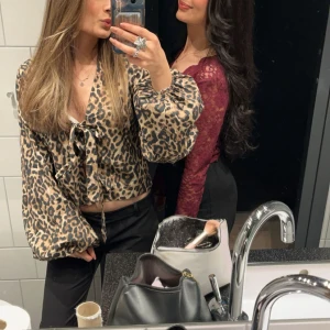 Leopardmönstrad croppad blus med knyt - Trendig croppad blus med leopardmönster och långa puffiga ärmar. Blusen har knyt framtill och v-ringad hals. ❤️❤️