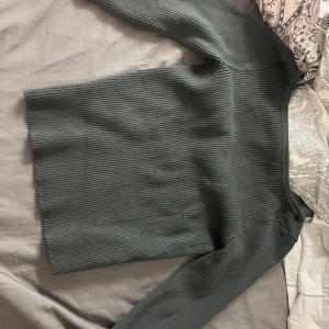 Mörkgrå ribbad tröja från H&M (openback) - Säljer en mörkgrön tröja från h&m i storlek 146/152. Använd väldigt lite. Bra skick