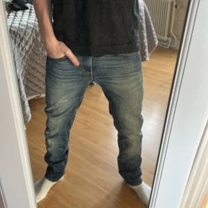 Tiger of Sweden jeans - Säljer ett par klassiska tiger of sweden jeans  med lätt slitning och raka ben. Byxorna har fem fickor, gylf med dragkedja och knapp samt kontrastsömmar. Perfekta för dig som gillar en tidlös stil. Storlek 30/32