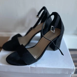 Svarta klackskor med ankelrem - Svarta klackar från Nelly, använda 2 gånger och är i bra skick. St 37