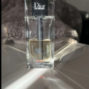 Dior Homme Sport Eau de Toilette - Fräsch och energisk herrparfym från Dior, Homme Sport. Kommer i en stilren, transparent glasflaska med svart spraymunstycke och silverdetaljer. Doften är citrusig och kryddig, perfekt för dig som gillar sportiga och moderna toner.