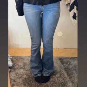 Blå bootcut jeans - Säljer ett par klassiska blå bootcut jeans med normal passform. Jeansen har en snygg tvätt och sitter tajt upptill med utsvängda ben. Perfekta till sneakers eller boots. Dom är i modellen tall, i referens är jag runt 180💞