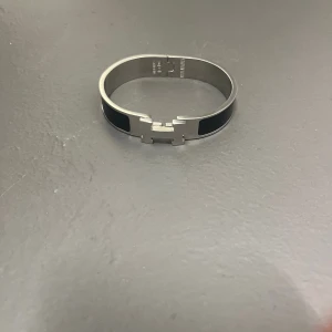 Silver färgat armband med H detalj - Säljer ett armband med en H detalj i silver, denna är riktigt fet till sommaren och man kan matcha den med ett bälte som jag har inne, kontakta mig vid intresse och minsta fundering. PRIS ÄR DISKUTERBART