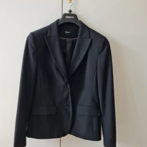 Kavaj/kostym från KappAhl strl 44 (dam) - Klassisk kavaj från KappAhl i storlek 44. Kan hämtas i Vallentuna.