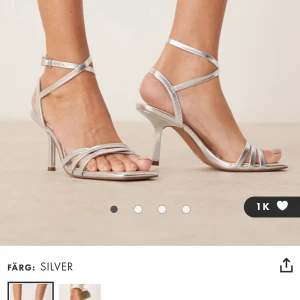 Silvriga sandaler med smala remmar och klack - Säljer dessa helt nya, oanvända klackar från asos, 399kr nypris. Klackhöjd 8 cm.Perfekta för exempelvis bal eller student! Kan sälja tillsammans med väskan för paketpris