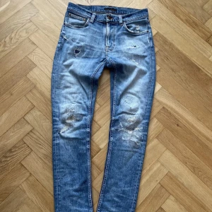 Nudie jeans med slitningar o lagningar - Säkert dem fetaste nudie jeansen du någonsin kommer att se! As sjuk tvätt med tväär goa slitningar och lagningar som är där med meningen. Storlek W28 L32 men mer som en W29 L32. Midjemätt: 41cm. Innerbenslängd: 72cm. Om du har minsta fundering fråga gärna! (Defekt på höger bak ficka)