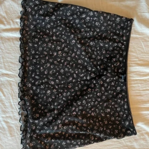 Svart Blommig mini skirt - Aldrig använd, har dock inte prislappen kvar💞 Stretchigt material💞 Midjemått: 35cm Längd: 33cm