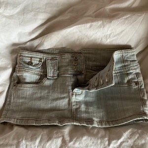 Ljusblå jeanskjol  - Lågmidjad jeanskjol! Midjemåttet rakt över:38 cm - längden på kjolen: 23 cm skulle säga att den sitter som en XS   