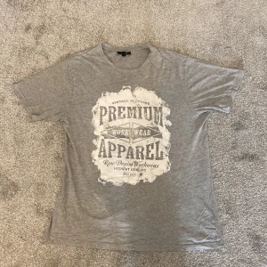 T-shirt med tryck - T-shirt  med stort vintageinspirerat tryck på bröstet där det står 'Premium Apparel'. 