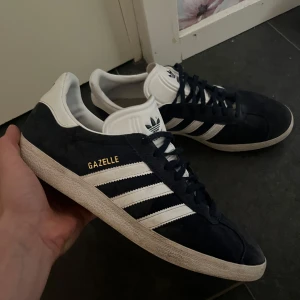 Adidas Gazelle - Säljer ett par klassiska Adidas Gazelle sneakers i mörkblå mocka, hör av vid intresse