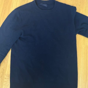 Kashmirtröja från A Days March - Säljer en mörkblå 100% kashmir tröja från a days march. Tröjan är storlek M men passar ockås i S. Använder inte lika ofta längre och därav säljs den. Den har två hål som knappt syns, en vid magen och en vid armbågen. Man ser hur lite de syns på bilderna.                                                                            Pris kan sänkas vid snabb affär!