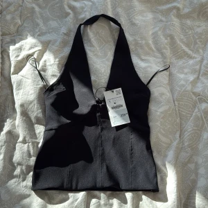 Svart halterneck topp från Zara - Snygg svart halterneck topp från Zara med djup urringning och smala axelband. Skitsnygg till sommarn. Tyvärr för liten 